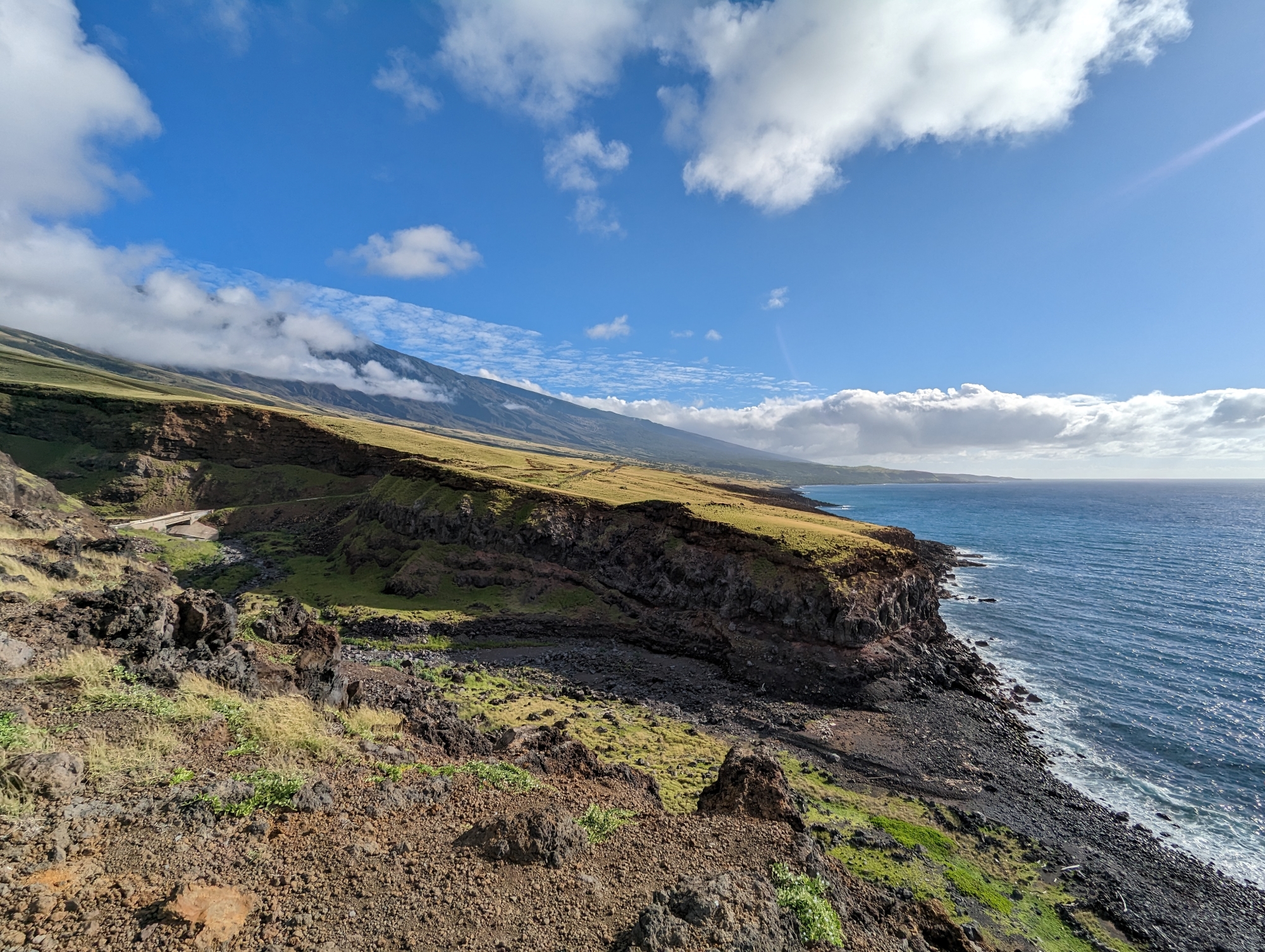 A picture of a rocky cliffside shore along the road to Hana.